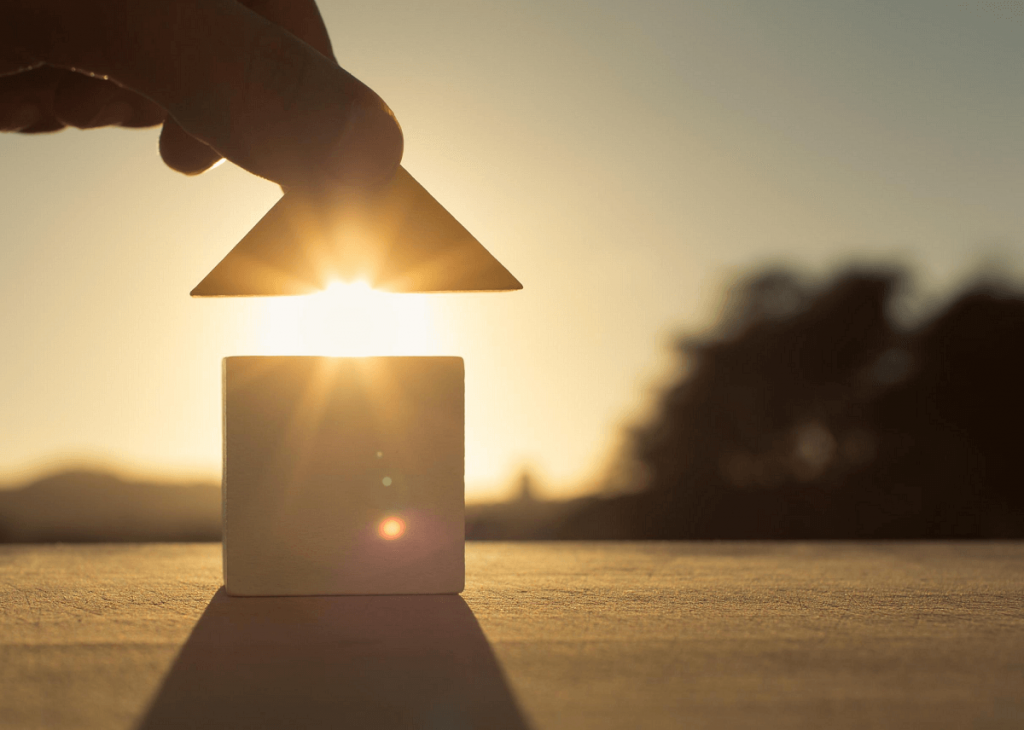 Building a home out of blocks on a patch of land at sunset